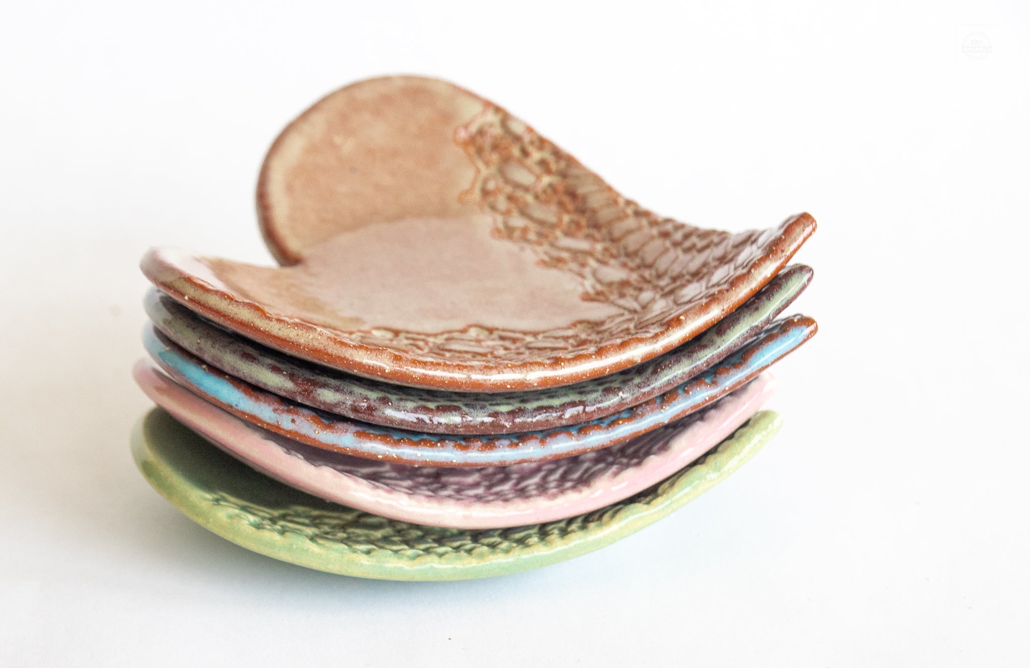 Stack of ceramic leaf-shaped dishes on a white background