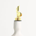 White oil dispenser with gold finish nozzle on a white background