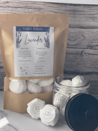 Lavender toilet bombs with packaging on a wooden surface