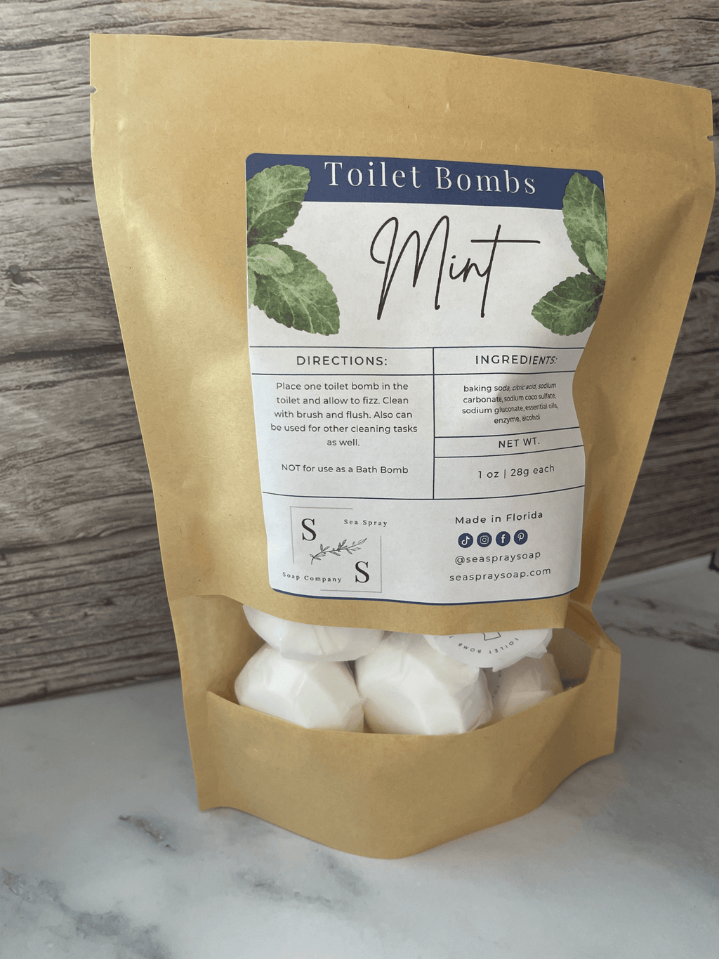 Package of Mint Toilet Bombs with a label on a marble surface.