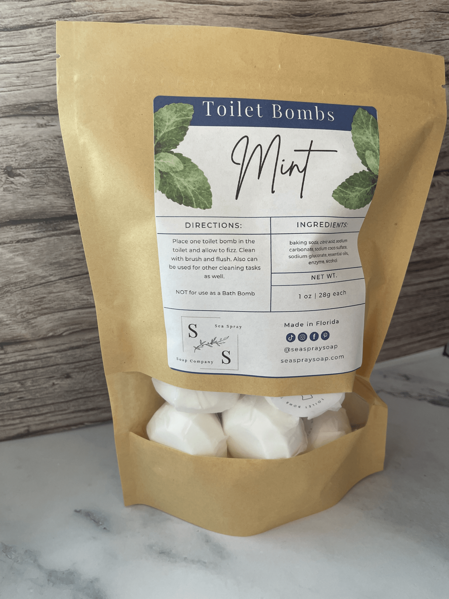 Package of Mint Toilet Bombs with a label on a marble surface.