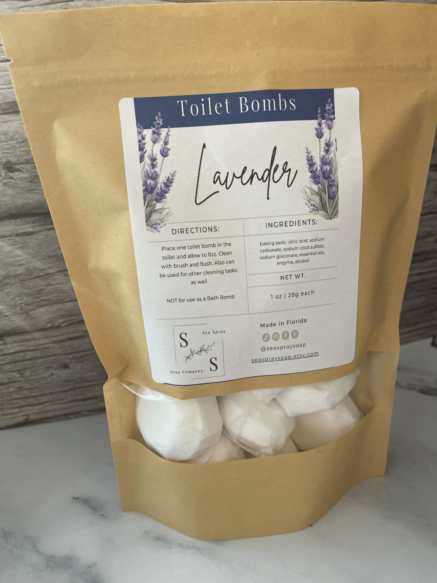 Kraft paper packaging of lavender toilet bombs with a label on a marble surface.