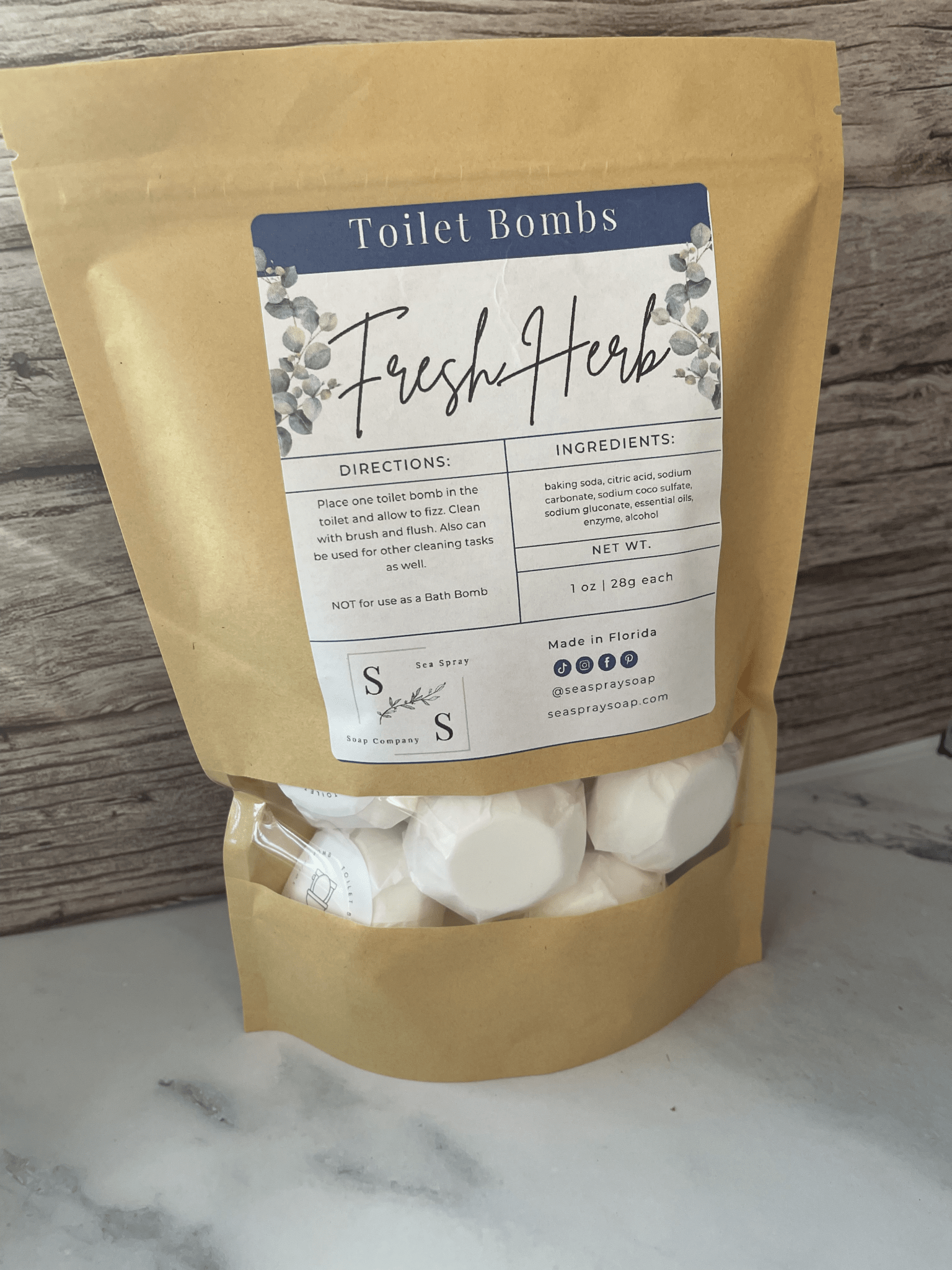 Bag of Fresh Herb toilet bombs with a label on a marble surface.